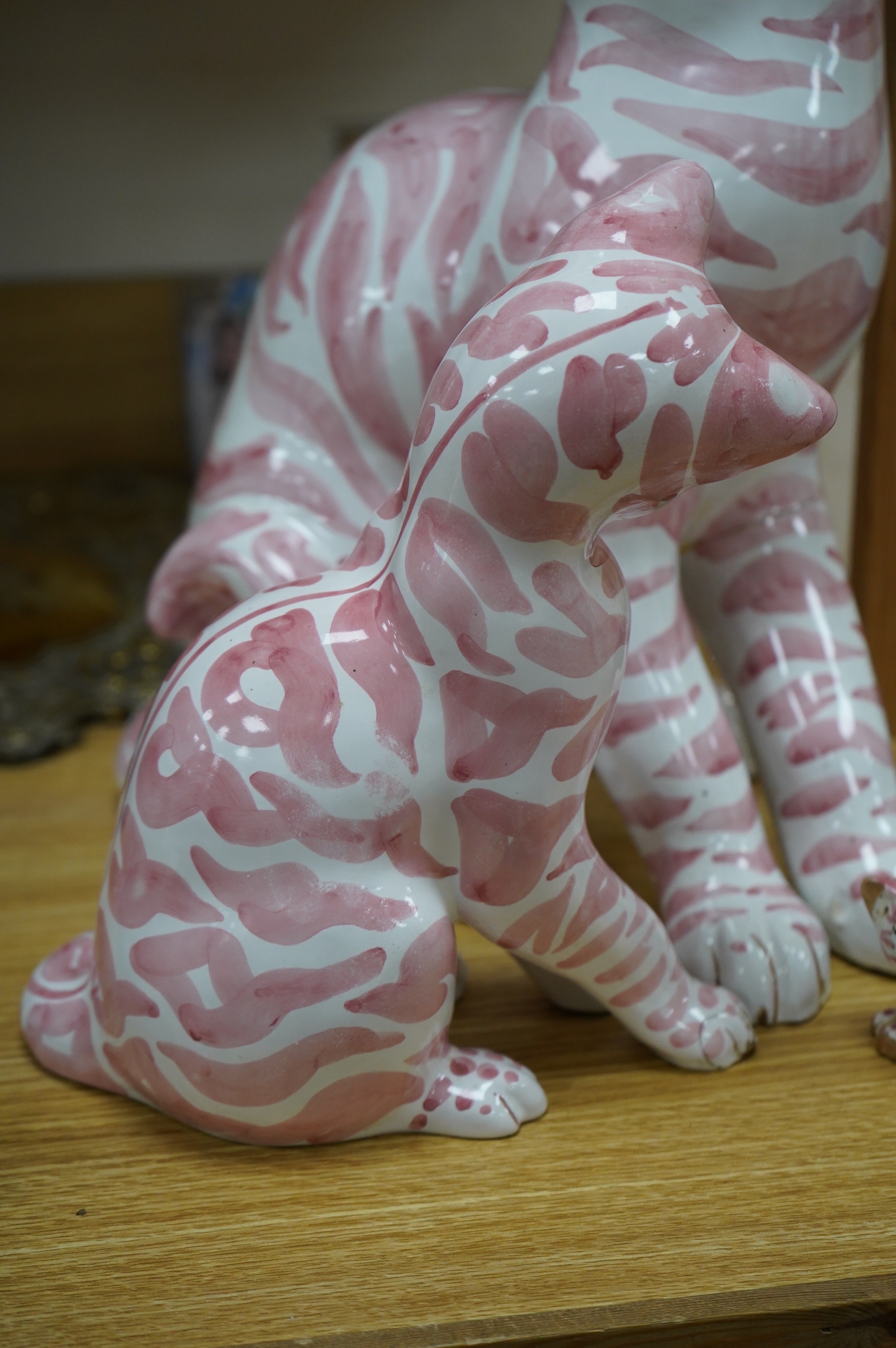 A large 1950's Italian pink maiolica seated cat and two smaller, largest 45cm. Condition - poor